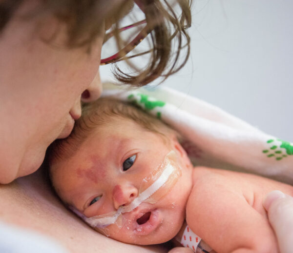 Mom holding baby skin to skin in the NICU