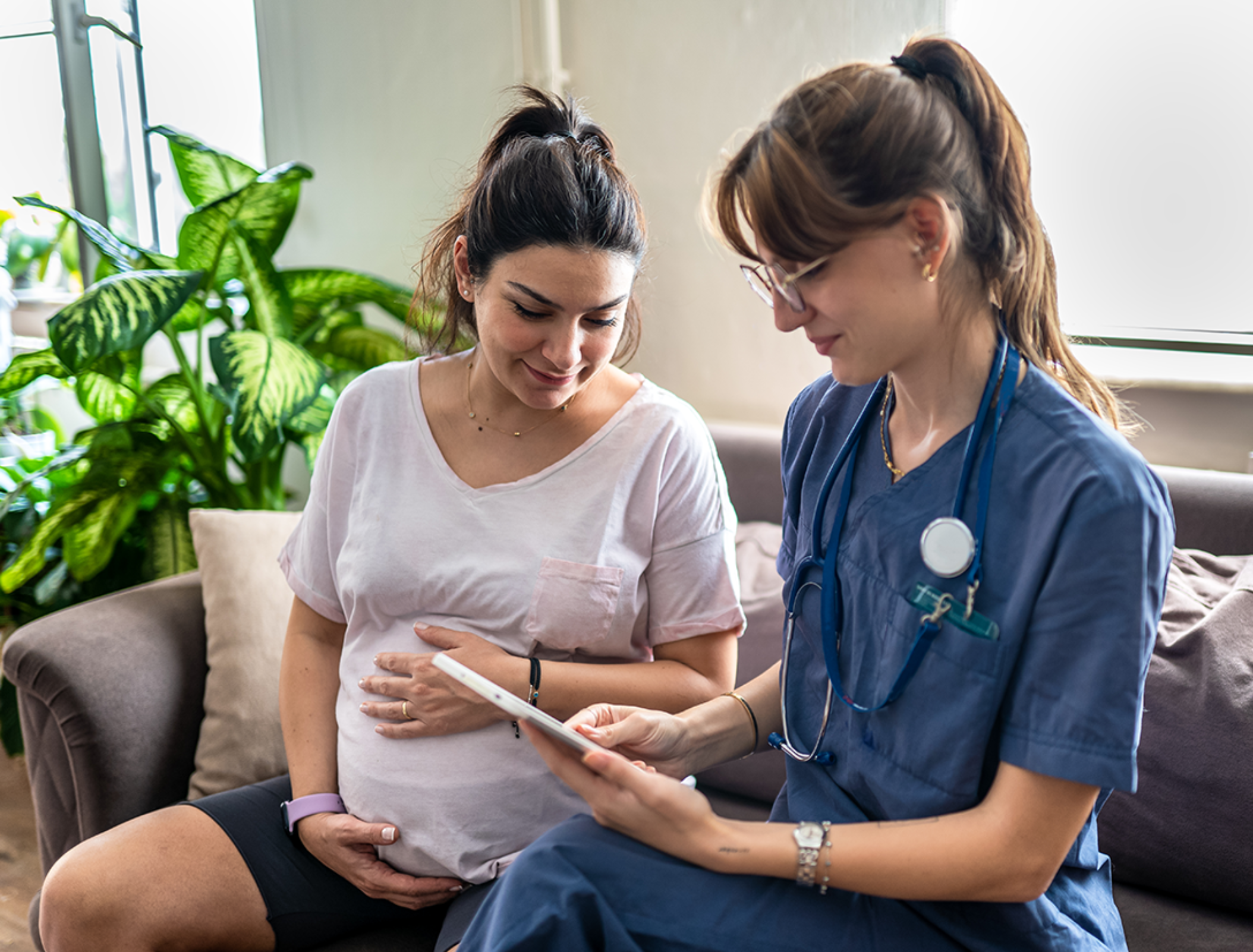 Home visitation nurse assisting pregnant woman with InJoy Health Education's Home Visitation Library resources