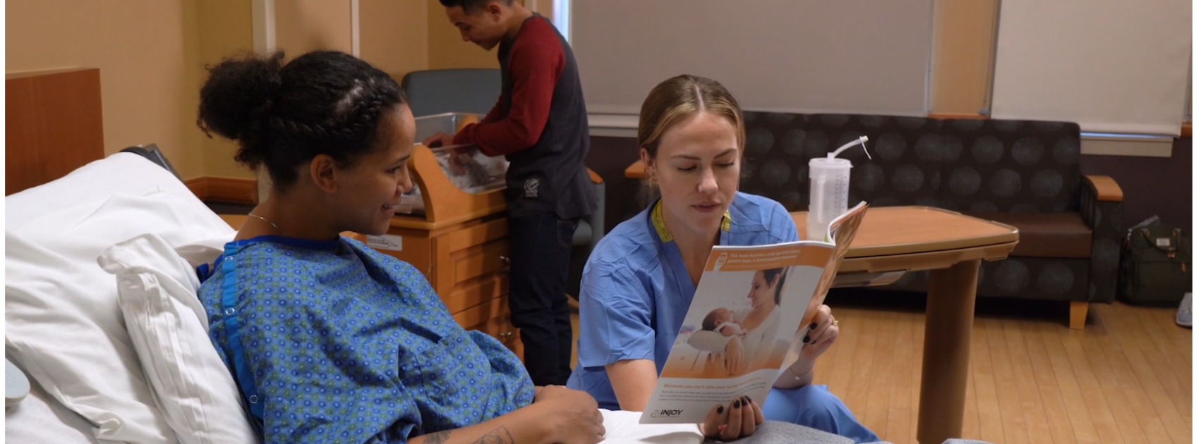 Nurse using InJoy Health Education's Understanding Postpartum Health & Baby Care Book with patient during bedside teaching.