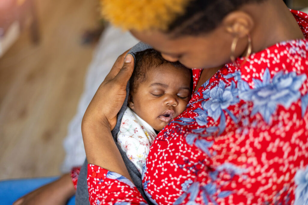 Newborn baby sleeping in mom's arms.