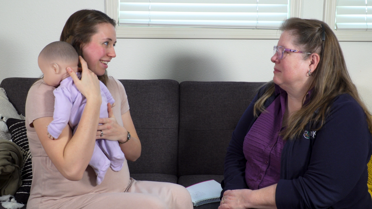 InCast, InJoy's podcast, guest Hilary Menke and host Debbie Young demonstrate newborn care with a doll.