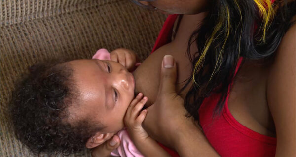 Mother breastfeeding her newborn baby, providing a clear demonstration from an InJoy Teen Video Library educational clip.