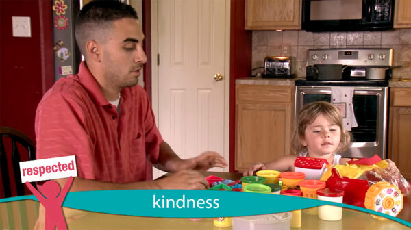 A father and his daughter playing with playdough at the kitchen table.