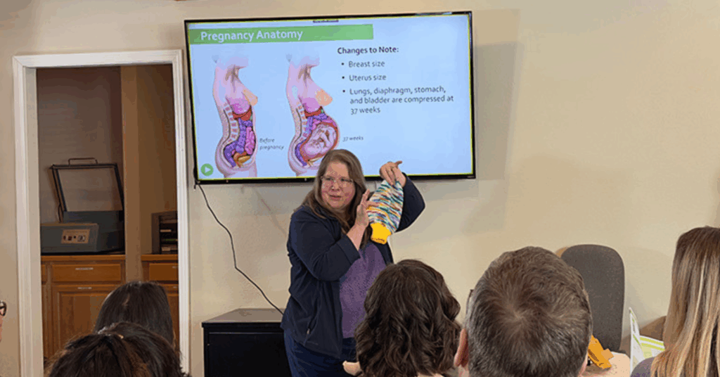Doula Debbie Young uses a knitted uterus as a teaching tool during a childbirth class.